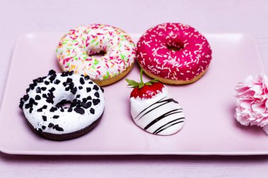 Pastel pembe arka planda kremalı çörekler. Tatlı çörekler. Pembe arka planda şekerler. Etkileyici bir fotoğraf. Kopyalama alanı olan yiyecek kavramı.