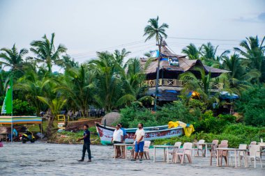 Goa, Hindistan 'da deniz kıyısında yürüyen insanların görüntüsü 