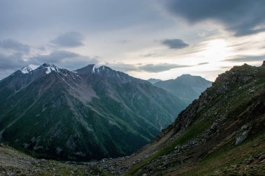 Kok-Tobe tepesinden Almatı şehrine yakın Tian Shan dağlarında muhteşem gün batımı manzarası 