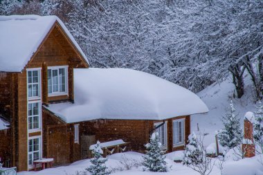 Almat yakınlarındaki Orta Asya'da Tian Shan dağlarında modern ahşap dağ evi karla kaplı. Kazakistan'da aktif yaşam, tırmanış, yürüyüş ve trekking için en iyi yer
