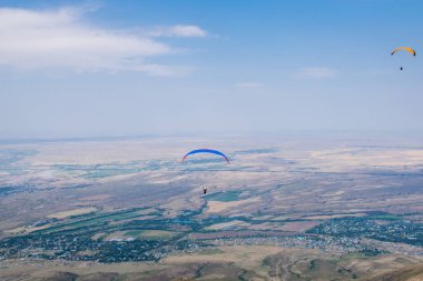 Ushkonir, Tian-Shan, Kazakistan dağlarında yamaç paraşütü yapan insanların manzarası
