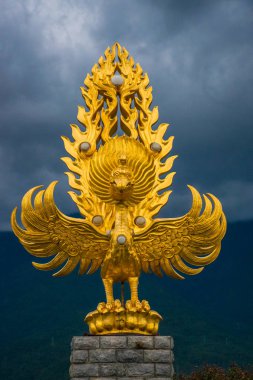 Dali Old Town yakınlarındaki Chongsheng Tapınağı önünde dramatik gökyüzü altında Altın Fhoenix heykeli, Yunnan eyaleti, Çin. Antik podalar Asya'nın popüler turistik yer.