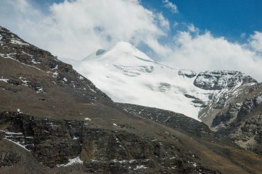 Orta Tibet'te kar ve buzla kaplı güzel yüksek dağ. Çin'de dağ yolu