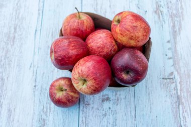 Ahşap bir masa üzerinde geri dönüşümlü kağıt kutusunda organik olgun elma. Pişirme malzemeleri. Hasat. Sürdürülebilir yaşam. Plastik ambalajlara hayır deyin.