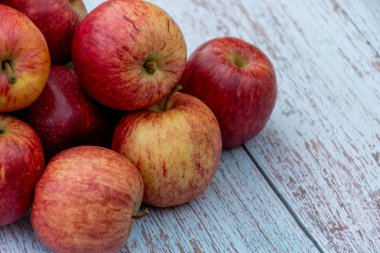 Bahçede ahşap bir masa üzerinde organik kırmızı olgun elma. Pişirme malzemeleri. Hasat.