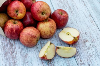 Ahşap bir masada organik olgun elmalar. Taze kesilmiş elma sağlıklı atıştırmalık. Pişirme malzemeleri. Hasat.