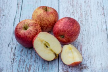 Ahşap bir masada organik olgun elmalar. Taze kesilmiş elma sağlıklı atıştırmalık. Pişirme malzemeleri. Hasat.