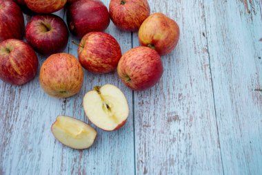 Ahşap bir masa üzerinde organik kırmızı olgun elma. Pişirme malzemeleri. Hasat. Taze kesilmiş elma sağlıklı atıştırmalık