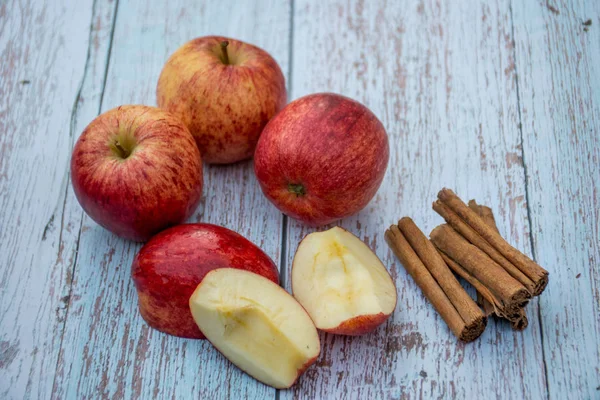 Maçãs maduras orgânicas e paus de canela em uma mesa de madeira. Maçã fresca. Cozinhar ingredientes. Colheita . — Fotografia de Stock