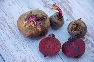 Taze organik pancar - üç bütün ve ikiye kesilmiş - rustik ahşap masa arka plan üzerinde. Pişirme malzemeleri. Hasat.