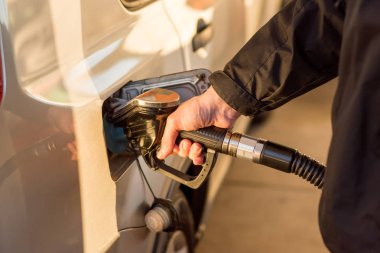 Benzin dolduran bir adam el ele tutuşuyor. Depoya benzin pompalıyorum. Benzin istasyonunda yakıt ikmali.