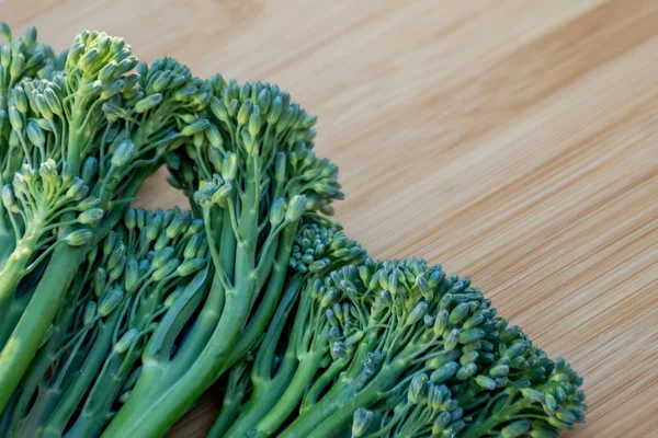 Un mucchio di broccolini freschi su uno sfondo di legno. Sano — Foto Stock