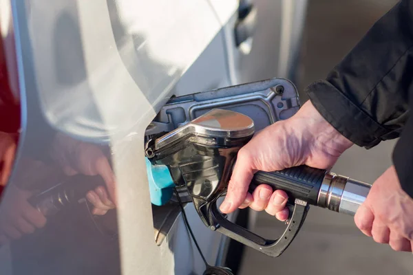 A man hand holding pump filling gasoline. Pumping petrol into the tank. A car refuel on gas station — Stock Photo, Image