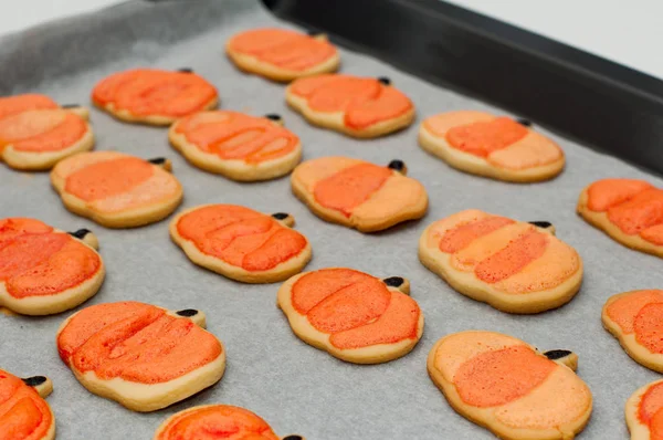 Zelfgemaakte Halloween koekjes versierd met glazuur op een dienblad. Sinaasappelpompoenen — Stockfoto