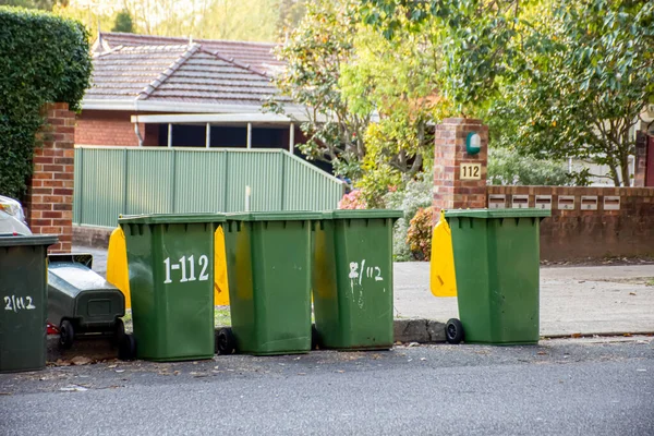 쓰레기를 재활용하기 위해 다채 로운 뚜껑 이 있는 오스트 레일리 아산 쓰레기통들 이 의회 쓰레기 수집을 위해 길가의 모서리에 늘어서 있다 — 스톡 사진