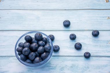 Süper yiyecek böğürtlenleri: ahşap arka planda bir kasede yaban mersini..