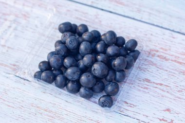 Tahta bir arka planda lezzetli taze süper yiyecek yaban mersini tepsisi.