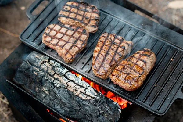 Bifes Carne Grelhando Uma Chapa Ferro Fundido Fogo Acampamento Cozinhar — Fotografia de Stock