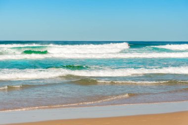 Beyaz köpüklü okyanus dalgaları donuk bulutlu bir günde sıçrar.