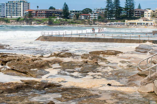 Sydney, Australia 2020-02-15 Ocean storm aftermath: A mass of thick foam covered the rocks following extreme storm weather at Cronulla, NSW, Australia