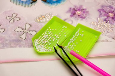 Elmas işlemeli kumaş. Akrilik elmaslar, kalem ve cımbız. Yakın çekim, seçici odaklanma