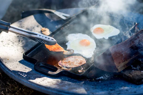 Ontbijtkamp Koken Grillen Van Knapperig Spek Eieren Een Gietijzeren Plaat — Stockfoto