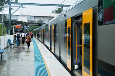 Sydney, Avustralya 2014-02-04 Yağmurlu bir günde yolcu ve trenle dolu banliyö tren istasyonunun bulanık görüntüsü.