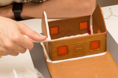 Kraliyet kremalı zencefilli ev yapmanın seçmeli odak noktası. Pencereler eritilmiş şekerlerle yapılır.