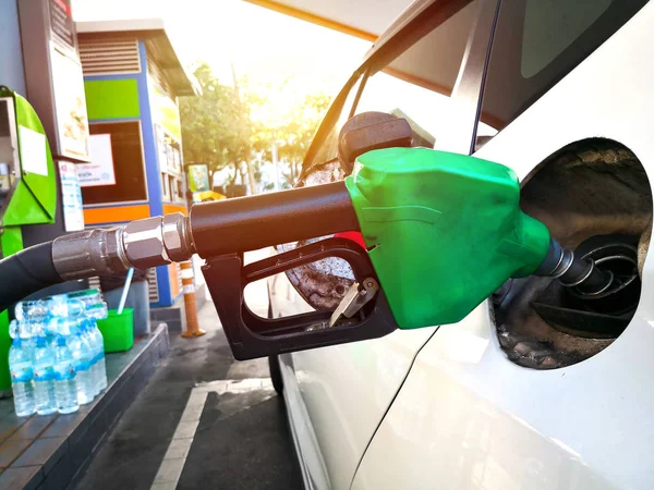 Reabastecimento de carro branco no posto de gasolina com bico de combustível verde . — Fotografia de Stock