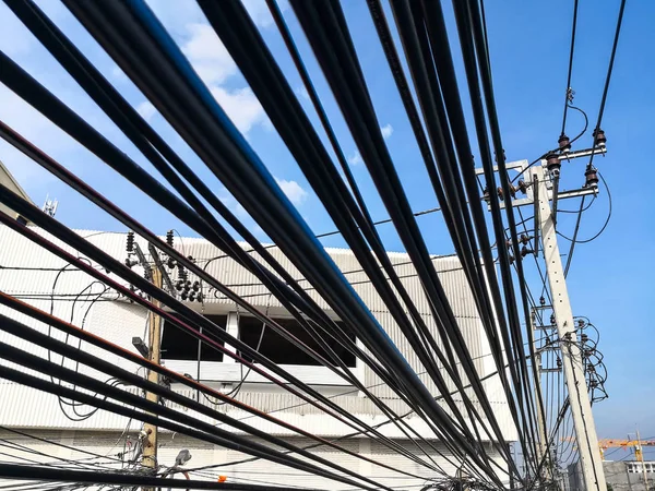 Wirrwarr von elektrischen Kabeln und Kommunikationsdrähten am Strommast. — Stockfoto