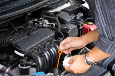 Adam veya oto tamircisi işçi elleri güvenlik için seyahat etmeden önce araba motoru yağı ve bakım kontrol.