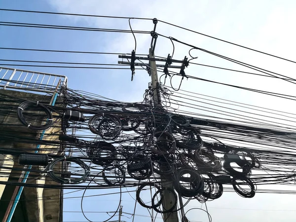 Сплетение электрических кабелей и коммуникационных проводов на электрическом полюсе . — стоковое фото