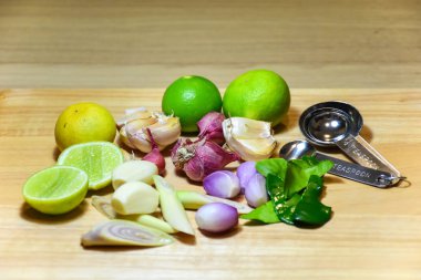 Gıda maddesi bitkisi. ahşap arka plan üzerinde kireç, limon otu, sarımsak, arpacık soğanı ve kaffir kireç yaprağı.