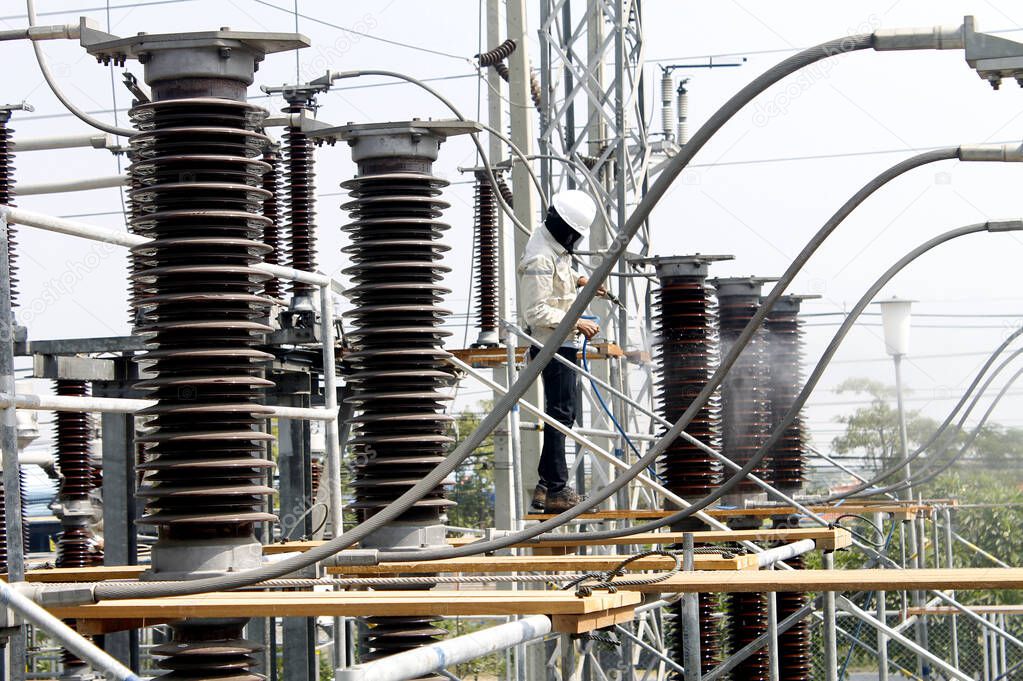 Workers maintenance an electrical power sub station.