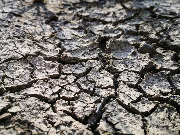 Texture di terra crepata essiccata a causa della stagione delle piogge e della siccità. — Foto Stock