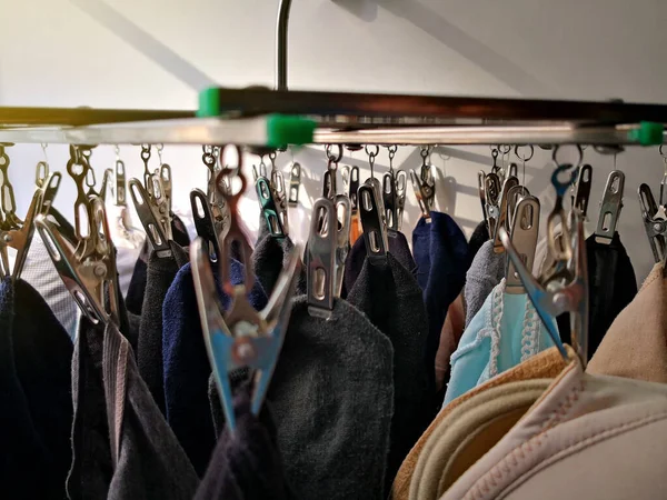Spodní prádlo a ponožka zavěšené na hliníkové šňůře na šaty se světlým pozadím. — Stock fotografie