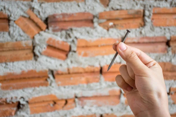 Vrouwelijke Hand Met Een Constructie Nagel Met Baksteen Muur Achtergrond — Stockfoto