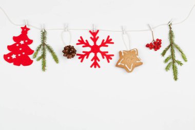 Noel kompozisyonu. beyaz ip kırmızı dekorasyon ve beyaz arka plan üzerinde köknar ağacı dalları üzerinde.