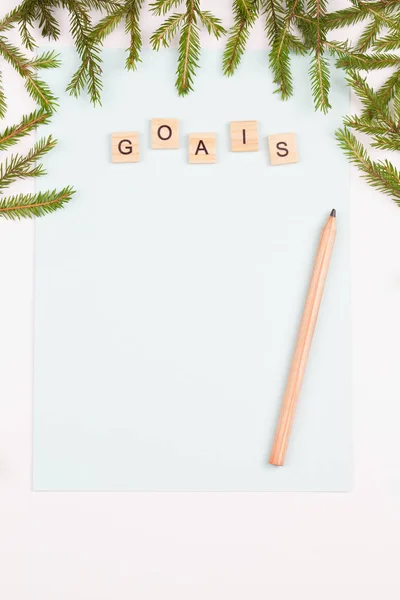 Fir branches, goals sheet on a white background. New goals. Christmas background. Flat lay, top view