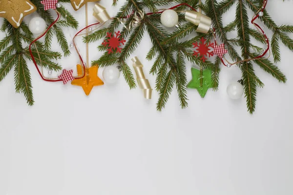 Ramas de árbol de Navidad con decoraciones rojas, piruletas y bolas blancas sobre fondo blanco — Foto de Stock