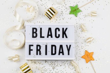 Beyaz ışık kutusu, altın yıldızlar, bayram kurdelesi, lolipop ve beyaz arka planda kutu satışı metni.