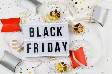 Beyaz ışık kutusu, altın yıldızlar ve beyaz arka planda ambalaj üzerine siyah cuma satışı metni