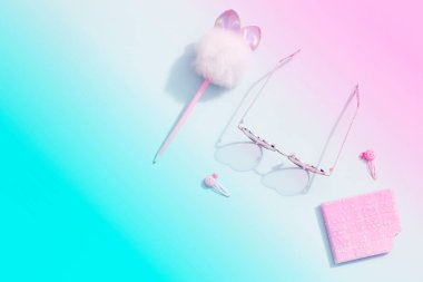 Pembe ve mavi parlak arkaplan üzerine pembe okul kırtasiyesi. Okula geri dönüş konsepti asgari. Üst görünüm düz yer kopyalama afişi