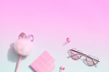 Pembe ve mavi parlak arkaplan üzerine pembe okul kırtasiyesi. Okula geri dönüş konsepti asgari. Üst görünüm düz yer kopyalama afişi