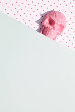 Pembe ve mavi arka planda kafatası şeklinde pembe lolipop. Yaratıcı Cadılar Bayramı asgari konsepti. düz yatay üst görünüm kopyalama alanı