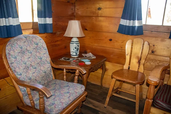 inside a Cabin sitting spot in the bedroom table lamp neat wooden chairs