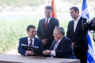 Prespes - Yunanistan, 17 Haziran, 2018:Greek Dışişleri Bakanı N. Kotzias (așağı R) ve Makedonya mevkidaşı N. Dimitrov (L) aşağı işaret A. Tsipras (R) ve Z. Zaev (L) olarak bir ön anlaşma arkasındayız