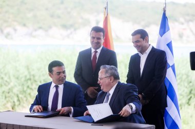 Prespes - Yunanistan, 17 Haziran, 2018:Greek Dışişleri Bakanı N. Kotzias (așağı R) ve Makedonya mevkidaşı N. Dimitrov (L) aşağı işaret A. Tsipras (R) ve Z. Zaev (L) olarak bir ön anlaşma arkasındayız