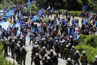 Pisoderi -Greece, July 17, 2018:Protestors holding Greek flags clash with riot police during a protest as the foreign ministers of Greece and Macedonia signed preliminary accord on renaming Macedonia. clipart