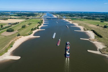 Rhine - Hollanda, 14 Temmuz 2018: Hollanda'nın bir bölgede Ren Nehri geçerken bir konteyner ile bir ticaret gemisine havadan görünümü